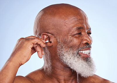 Buy stock photo Studio, smile and black man with cotton swab for self care, hygiene maintenance and removal of wax. Happy, mature person and hand with product for ear health, cosmetics or cleaning on blue background