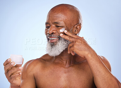 Buy stock photo Skincare, cream and product with black man in studio for sunscreen, anti aging or beauty. Cosmetics, mockup or self care with lotion on face of model on blue background for facial and spa treatment