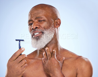 Buy stock photo Razor, injury and man with beard in studio for grooming, hair removal or self care treatment. Accident, clean and mature male person with shaver for facial epilation routine by blue background.