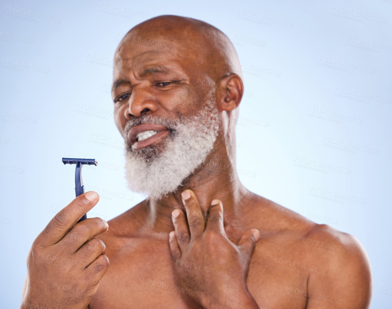 Buy stock photo Razor, injury and man with beard in studio for grooming, hair removal or self care treatment. Accident, clean and mature male person with shaver for facial epilation routine by blue background.