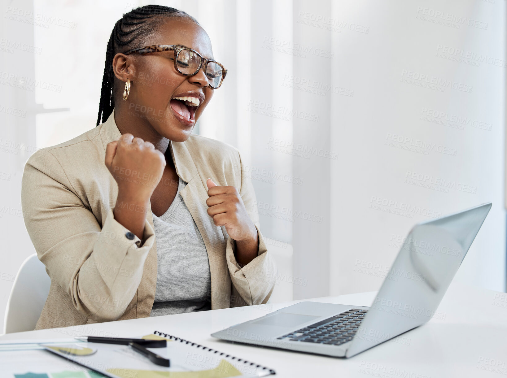 Buy stock photo Shot of a young businesswoman cheering while using a laptop in an office