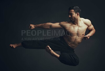 Buy stock photo Full length shot of an unrecognisable man performing a martial arts kick in the studio