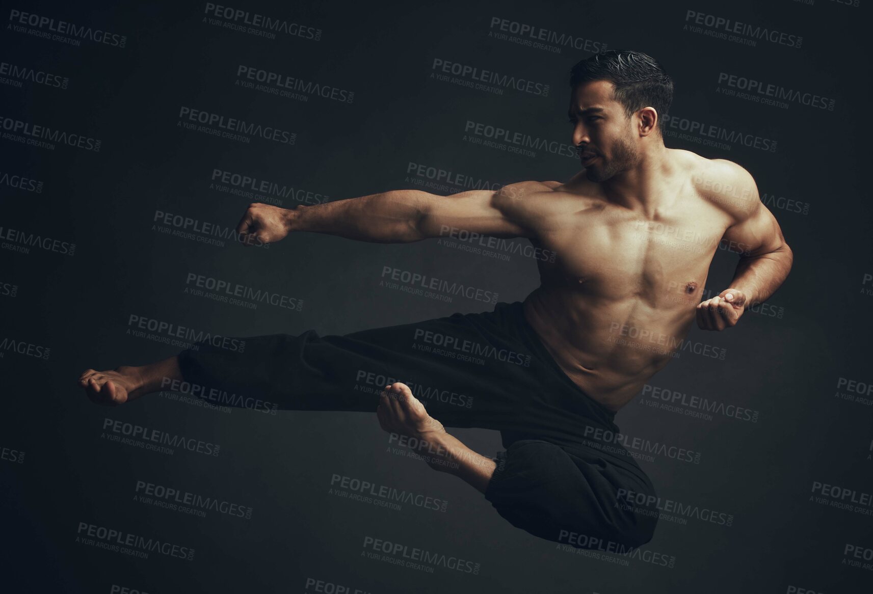Buy stock photo Full length shot of an unrecognisable man performing a martial arts kick in the studio