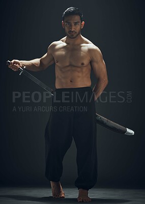 Buy stock photo Full length shot of a handsome young man standing alone in the studio and posing with a broadsword