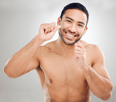 Buy stock photo Hygiene, man and dental floss in portrait, routine or wellness in oral health, tooth on gray background. Male person, cleaning and fresh breath with confidence for care, teeth and mouth in studio
