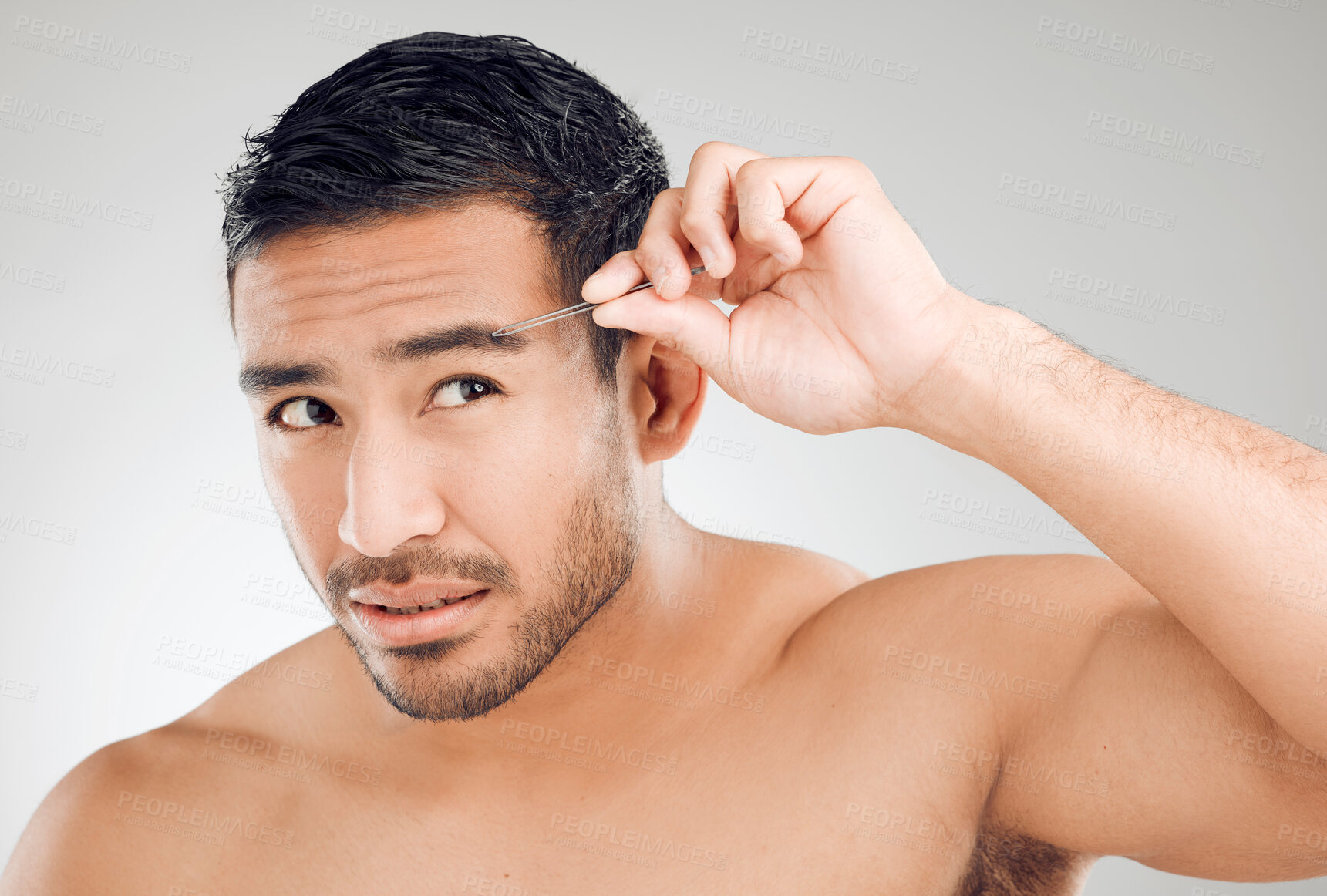 Buy stock photo Man, tweezers and hair removal for eyebrows or skincare for morning routine in studio. Asian male person, wellness and maintenance for face with epilation, tools and self care by white background  