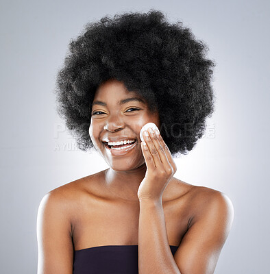 Buy stock photo Studio shot of an attractive young woman wiping her face with cotton against a grey background