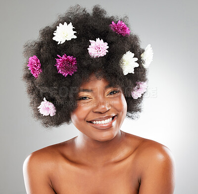 Buy stock photo Black woman, portrait and flowers in afro or studio for hair care, natural beauty and growth with shine or glow. Girl, pink plants and smile for wellness, organic cosmetics and gray background.