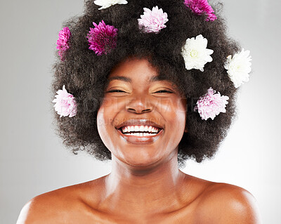 Buy stock photo Portrait, hair care and black woman with flowers, smile and natural beauty on grey studio background. African person, face and model with afro, happiness and organic treatment with grooming and shine