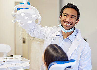 Buy stock photo Shot of a young dentist getting ready to conduct a procedure on his patient