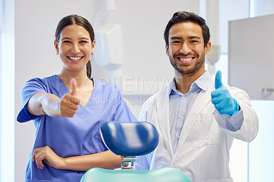Buy stock photo Dentist team, happy portrait and thumbs up for support, thank you or like emoji. Assistant woman and asian man or healthcare staff for dental care, oral health and wellness with a chair at practice