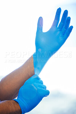 Buy stock photo Shot of an unrecognisable dentist putting on rubber gloves