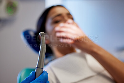 Buy stock photo Shot of a young woman experiencing pain and anxiety while having a dental procedure performed on her