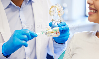 Buy stock photo Shot of a dentist showing his patient a model of teeth before her procedure