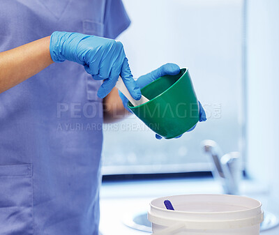 Buy stock photo Shot of an unrecognisable dentist preparing plaster to make a mould during a dental procedure