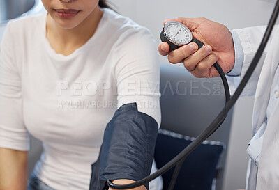 Buy stock photo Shot of a doctor examining a woman with a blood pressure gauge
