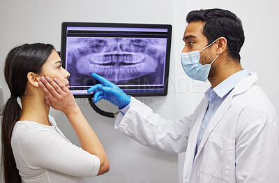 Buy stock photo Shot of a dentist discussing the results of a patient’s teeth x ray