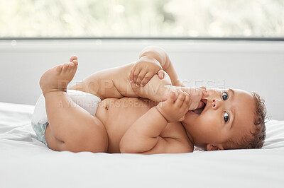 Buy stock photo Baby, portrait and child sucking feet on bed in home having fun and enjoying time alone. Face, newborn and playing with foot, toes and cute infant, kid or toddler with growth, development and relax