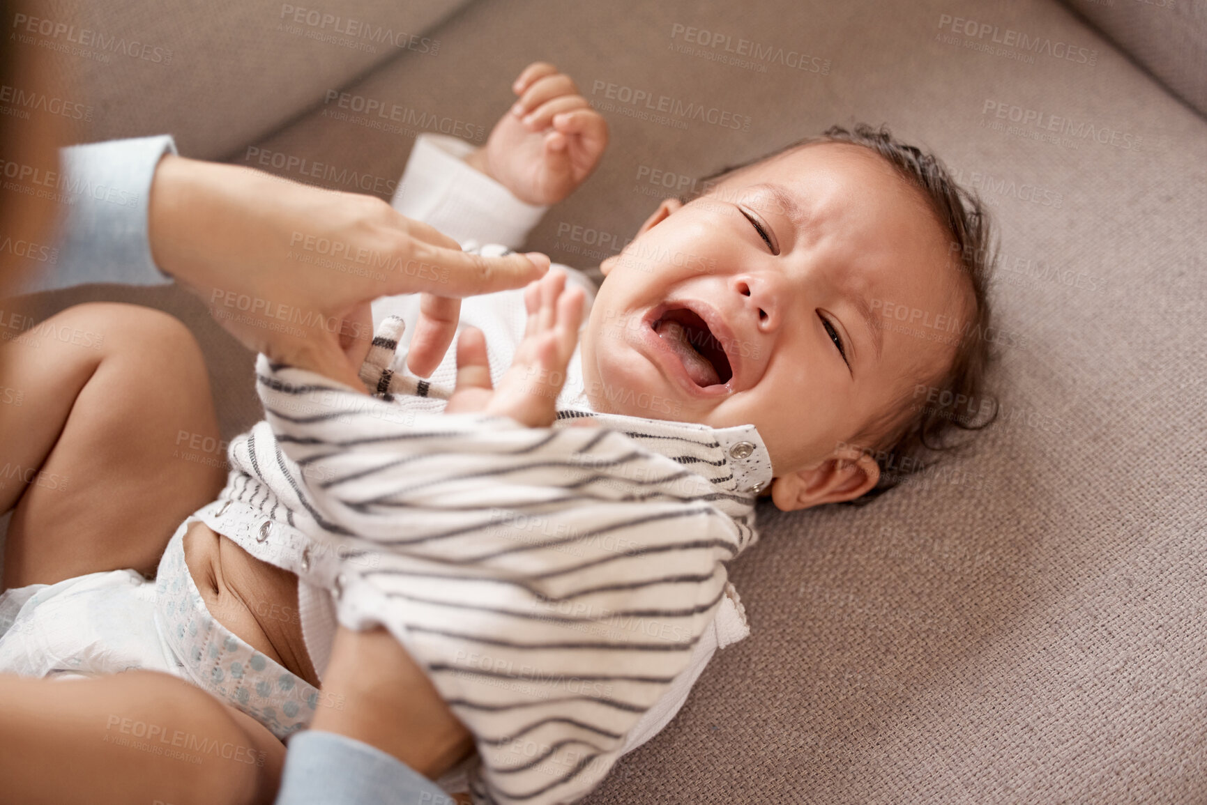 Buy stock photo Clothes, changing or dressing and baby crying with parent on sofa in living room of home for development. Tears, tantrum or sad with person and tired toddler in apartment for security from above