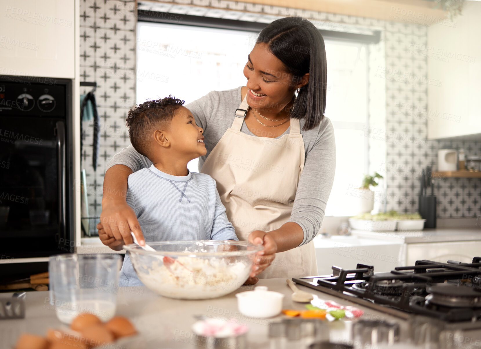 Buy stock photo Shot of an adorable little boy baking with his mom at home