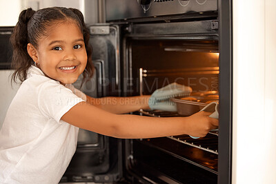 Buy stock photo Portrait of an adorable little girl baking muffins in the oven at home