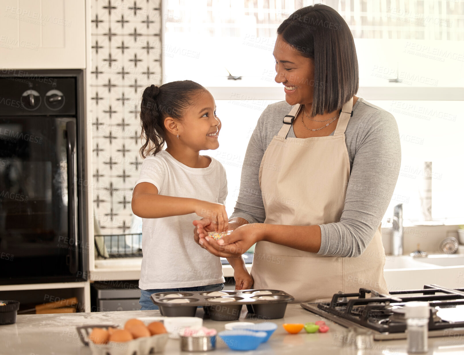 Buy stock photo Shot of an adorable little girl baking with her mom at home