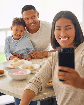 Buy stock photo Shot of a young woman taking selfies during lunch with her family outdoors
