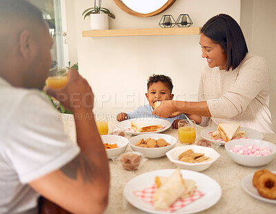 Buy stock photo Shot of a happy young family having a leisurely lunch in their backyard at home