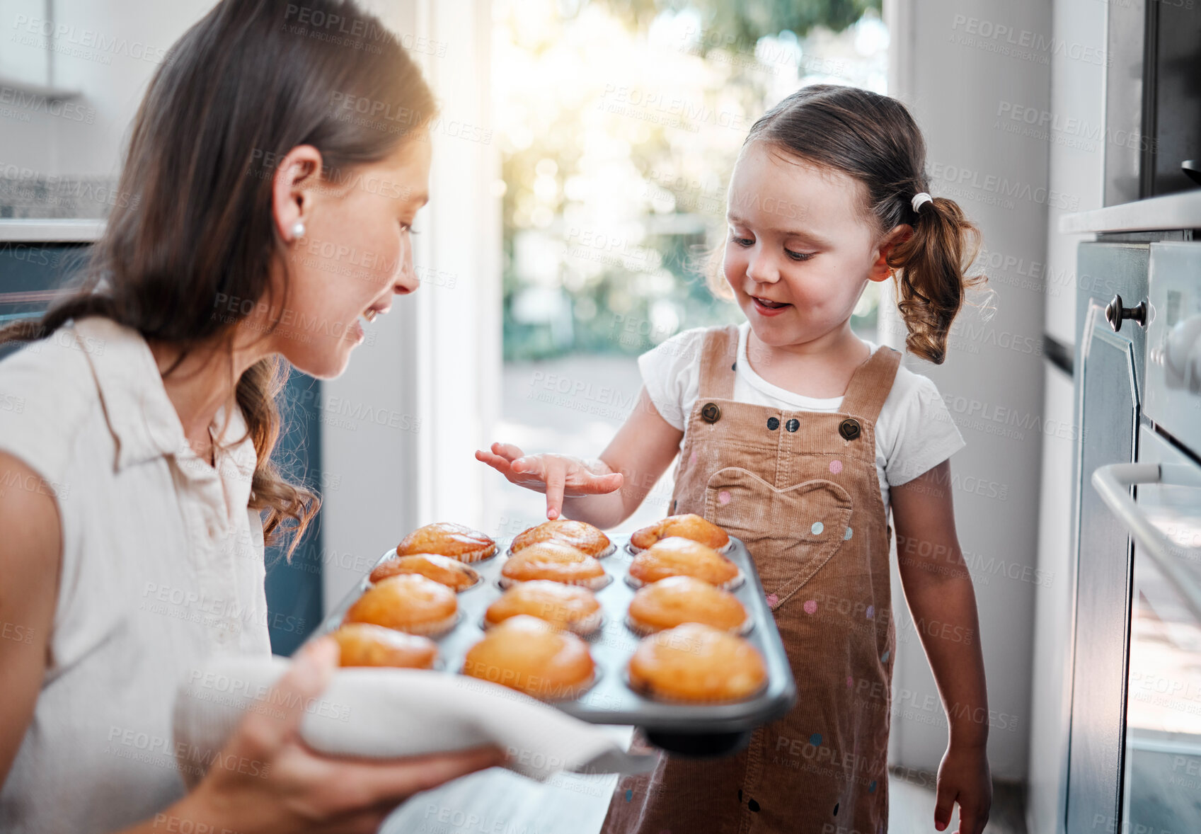 Buy stock photo Woman, girl and baking muffins in home, happiness and sweet treat with mother or fresh dessert. Cupcakes, kitchen and childhood with parent for bonding, family and weekend break with people together