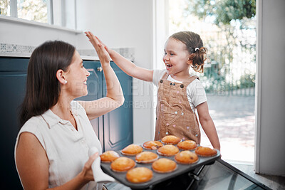 Buy stock photo Shot of a woman sharing a high-five with her daughter while baking