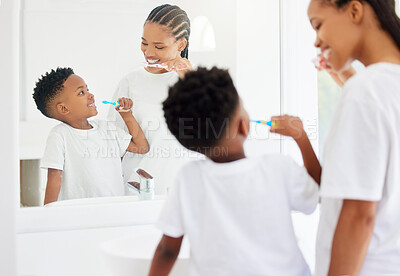 Buy stock photo Happy, mom and boy with toothbrush for brushing teeth for dental health, daily routine and gum wellness. Black family, back and mirror in bathroom or home for oral hygiene, cavity and fresh breath.