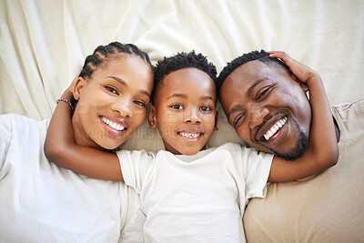 Buy stock photo African family, portrait and happy kid with parents in bedroom to relax in home above. Face, mother and father in bed with boy child in top view for resting, laughing and embrace for bonding together