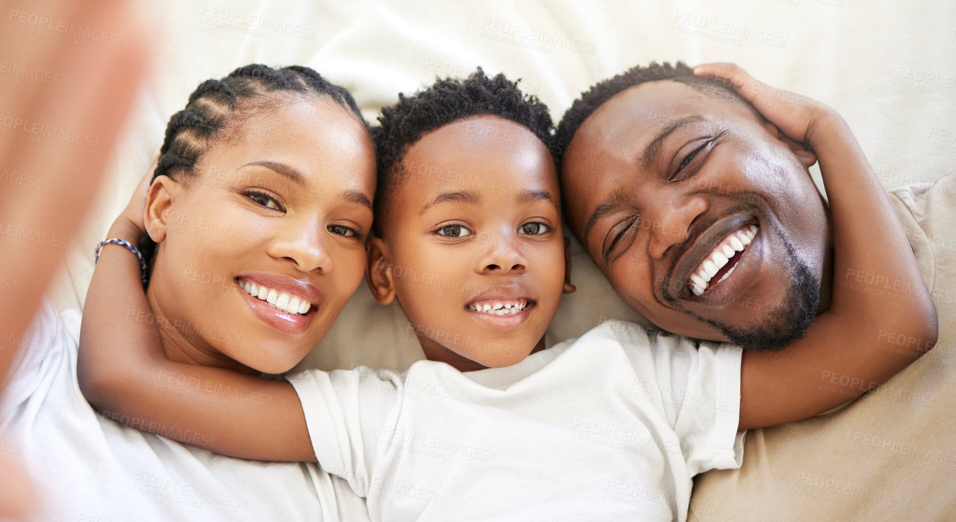 Buy stock photo Black family, portrait and selfie of happy kid with parents in bedroom to relax in home above. Face, mother and father with boy child in top view for picture, laughing and embrace for love together