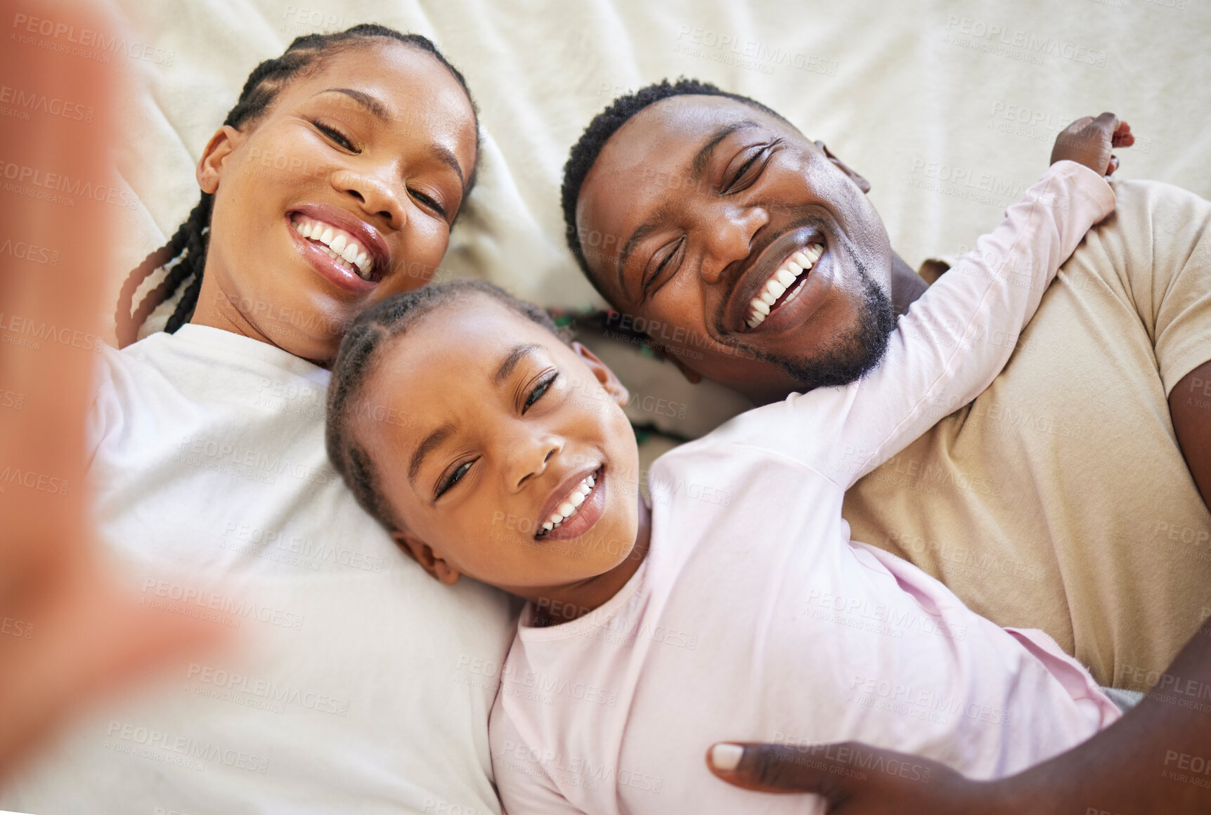 Buy stock photo African family, portrait and selfie of happy kid in bedroom with parents to relax in home above. Face, mother and father with girl child in top view for picture, laughing or embrace for love together