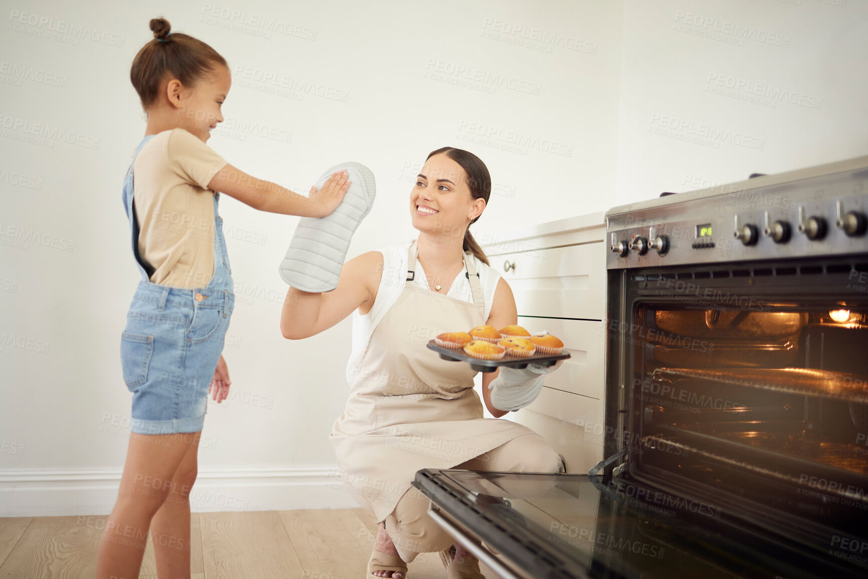 Buy stock photo Mother, child and high five for baking in kitchen with muffin success, celebration and bonding for learning achievement. Happy, woman and girl with oven dessert, support and teaching memory at house