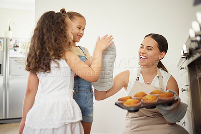 Buy stock photo Shot of a young mother and her daughter giving each other a high five while baking at home