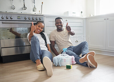 Buy stock photo Shot of a young couple showing a thumbs up after cleaning up at home