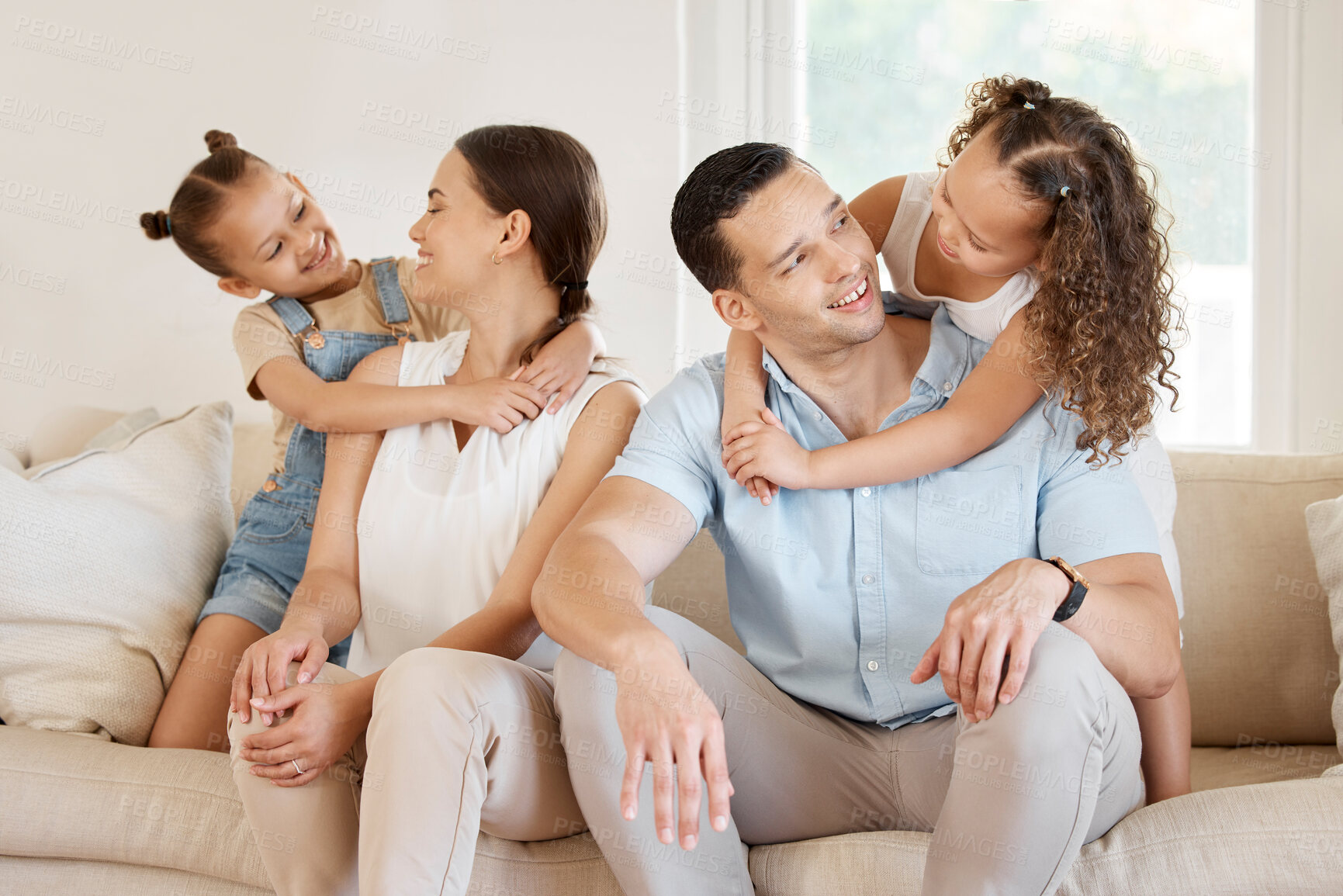 Buy stock photo Shot of a couple and their two daughters sitting on the couch at home