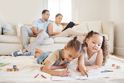 Buy stock photo Shot of two little girls doing artwork while their parents sit in the background