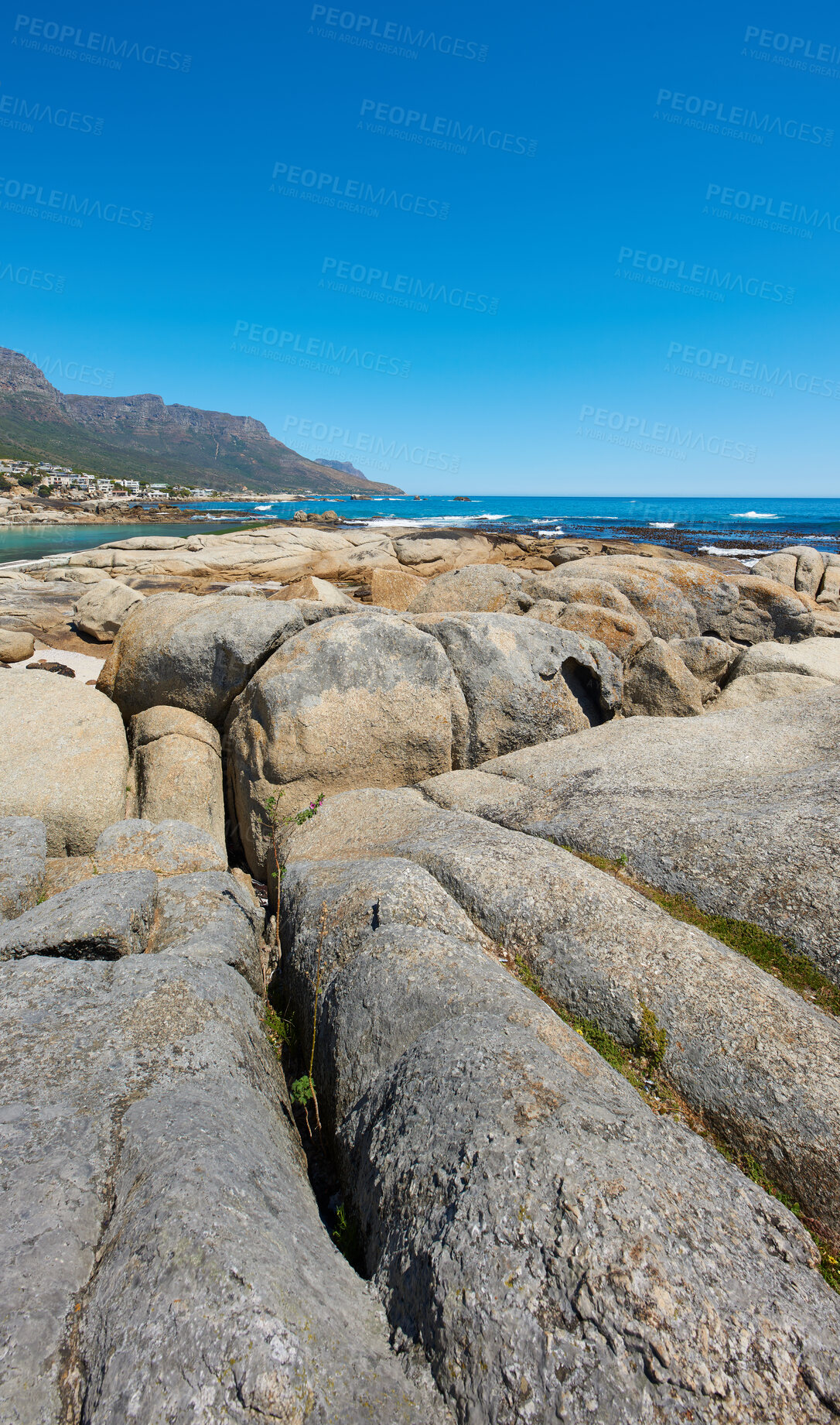 Buy stock photo Landscape, scenic and copyspace view of rocks and boulders on the seaside or coast against a clear blue sky in summer. Beautiful, peaceful and calm natural environment at the beach with copyspace