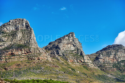 Buy stock photo Beautiful outdoor mountain landscape with a blue sky copyspace in nature. Outside view of high mountains, green grass, and plant life. Relaxing natural background of rock formations on a summer day