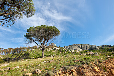 Buy stock photo Natural landscape view of mountain in nature. Scenic look of rocky hills and grassy terrain on a sunny day in the outdoors. Big blue sky background with greenery and small separated clouds outside