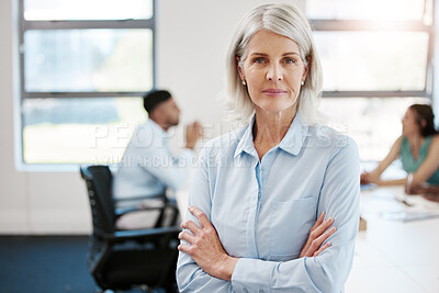 Buy stock photo Portrait of a confident mature businesswoman standing with her arms crossed in an office