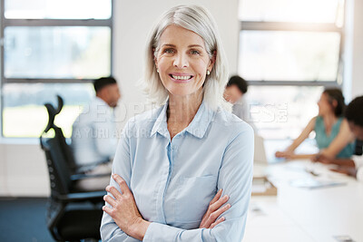 Buy stock photo Portrait of a confident mature businesswoman standing with her arms crossed in an office