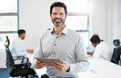 Buy stock photo Portrait of a confident mature businessman using a digital tablet in an office