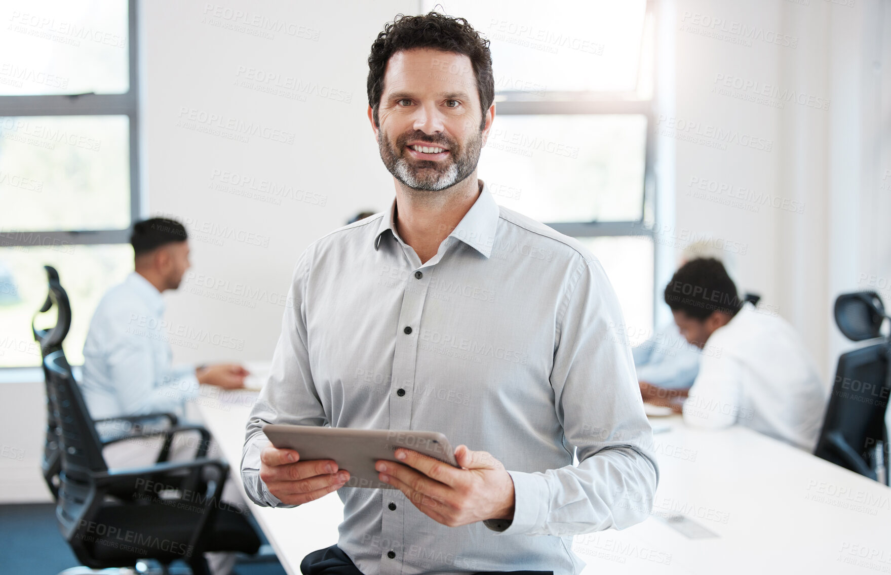 Buy stock photo Portrait of a confident mature businessman using a digital tablet in an office