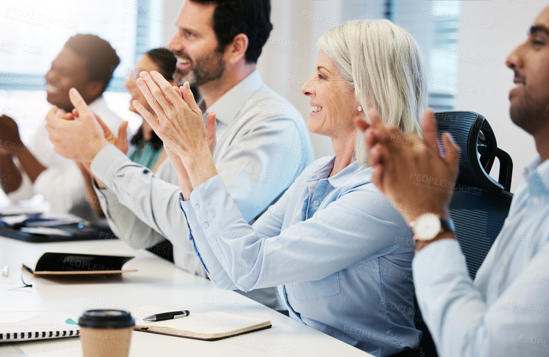 Buy stock photo Shot of a mature businesswoman applauding with her colleagues during a meeting in an office