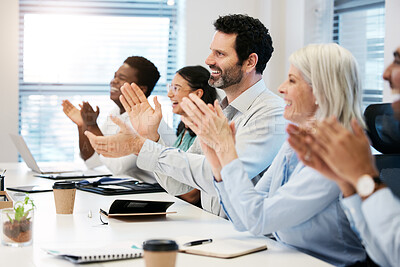Buy stock photo Shot of a mature businessman applauding with his colleagues during a meeting in an office
