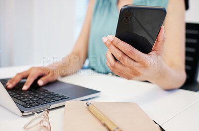 Buy stock photo Closeup shot of an unrecognisable businesswoman using a laptop and cellphone in an office