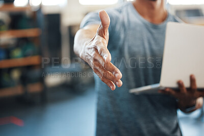 Buy stock photo Closeup shot of an unrecognisable man extending a handshake while using a laptop in a gym